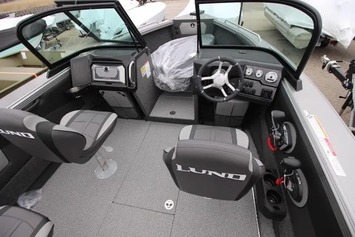 Slide: The Image of 2026 Lund 2075 Tyee boat interior with steering wheel, seating, and dashboard controls. - 8
