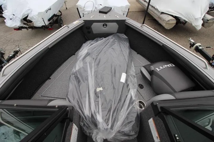 Slide: The Image of 2026 Lund 2075 Tyee boat interior with covered seating and storage area. - 9