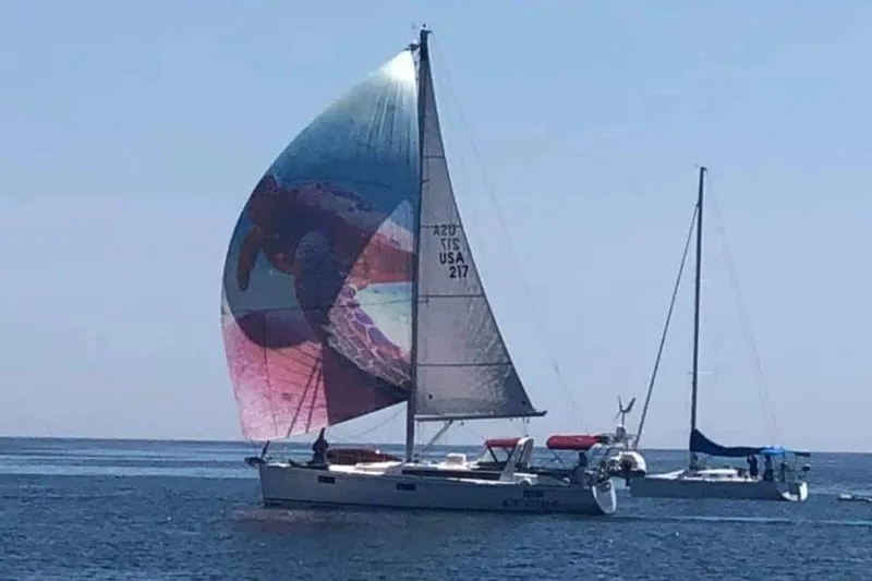 The Image of 2015 Beneteau Oceanis 48 sailboat with colorful spinnaker on calm sea. - 0
