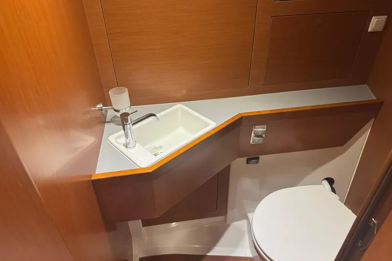 Slide: The Image of Beneteau Oceanis 48 (2015) yacht bathroom with modern sink and toilet. - 12