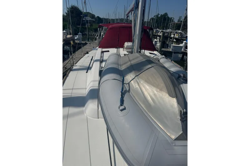 Slide: The Image of 2015 Beneteau Oceanis 48 sailboat deck with red canopy, docked at marina. - 23