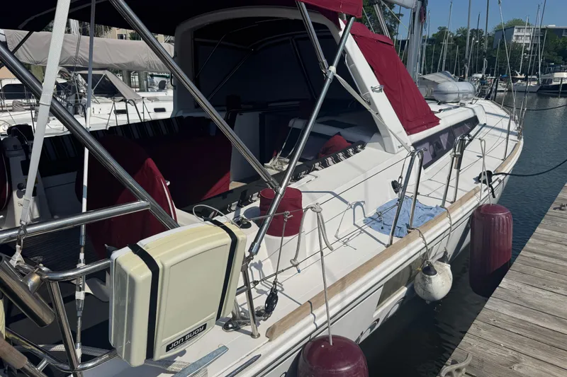 Slide: The Image of 2015 Beneteau Oceanis 48 sailboat docked, featuring red canopy and fenders. - 25