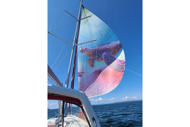 Slide: The Image of Beneteau Oceanis 48 sailboat with vibrant sea turtle spinnaker, 2015 model, sailing on open water. - 26