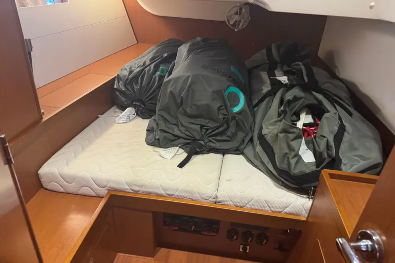 Slide: The Image of Cabin interior of 2015 Beneteau Oceanis 48 with storage bags on mattress. - 8