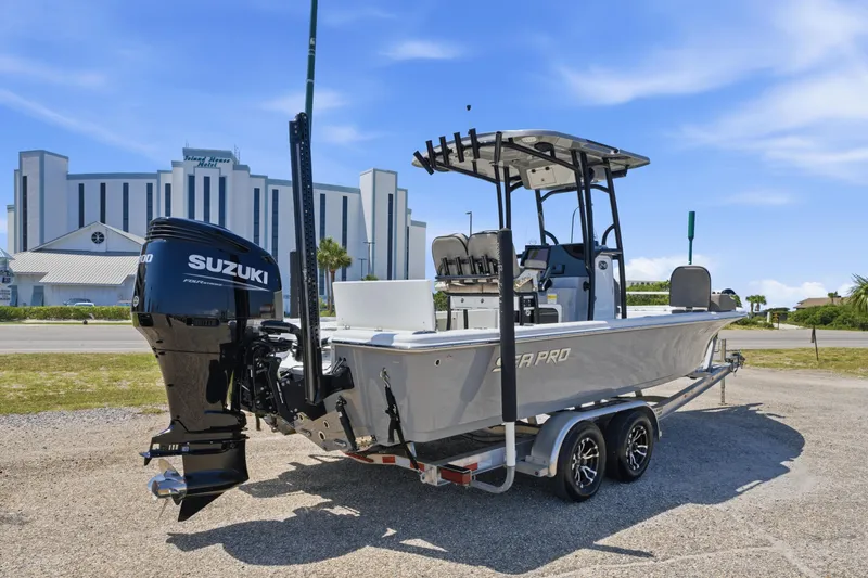 Slide: The Image of 2023 Sea Pro 248 Bay boat with Suzuki engine on trailer, parked near a hotel. - 10