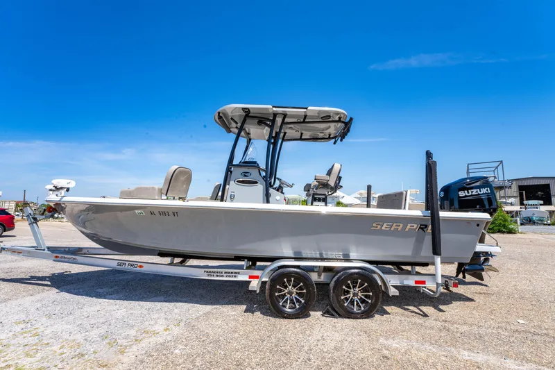 Slide: The Image of 2023 Sea Pro 248 Bay boat on trailer under clear blue sky. - 13