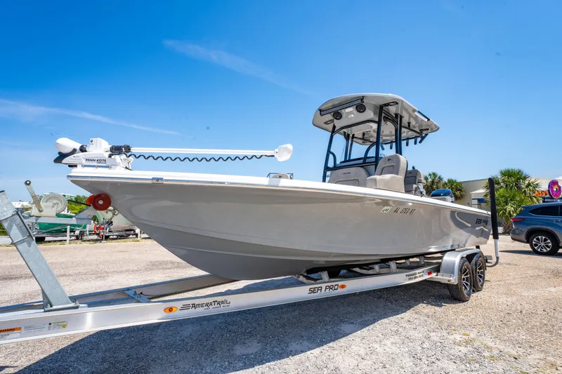 Slide: The Image of 2023 Sea Pro 248 Bay boat on trailer under clear blue sky. - 14