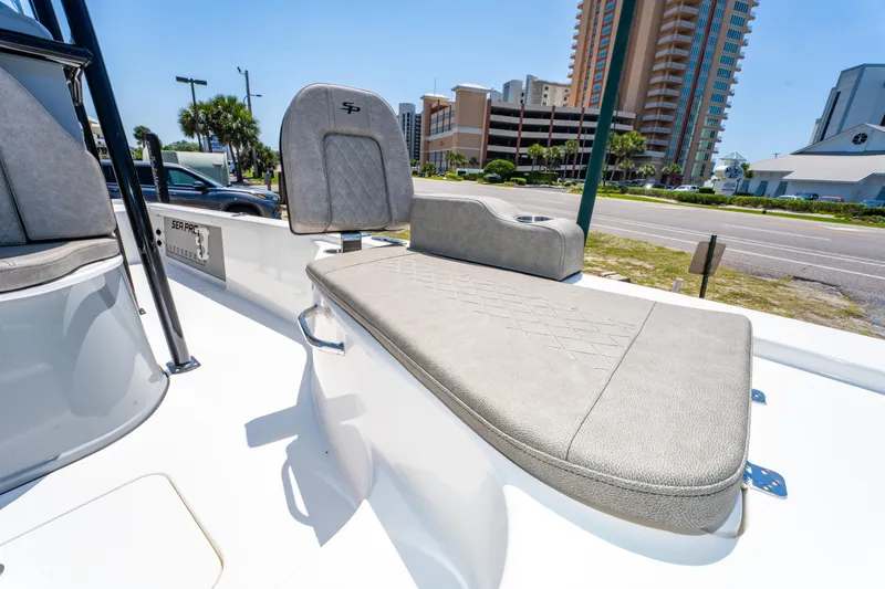 Slide: The Image of 2023 Sea Pro 248 Bay boat interior with cushioned seating and urban backdrop. - 34