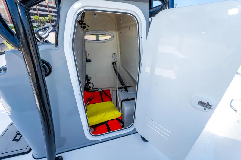 Slide: The Image of 2023 Sea Pro 248 Bay boat storage compartment with safety gear visible. - 36