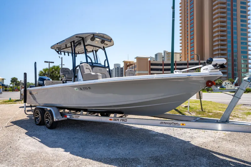 Slide: The Image of 2023 Sea Pro 248 Bay boat on trailer, parked near tall buildings. - 9