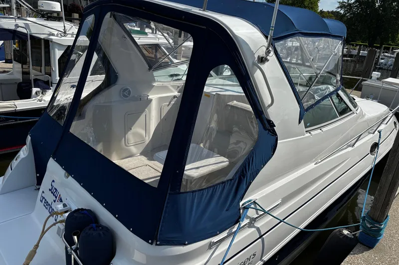 Slide: The Image of 2005 Cruisers Yachts 280 CXi Express with blue cover docked at marina. - 18