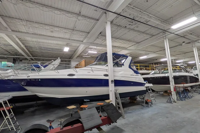Slide: The Image of 2005 Cruisers Yachts 280 CXi Express in indoor storage, showcasing sleek design and blue accents. - 22
