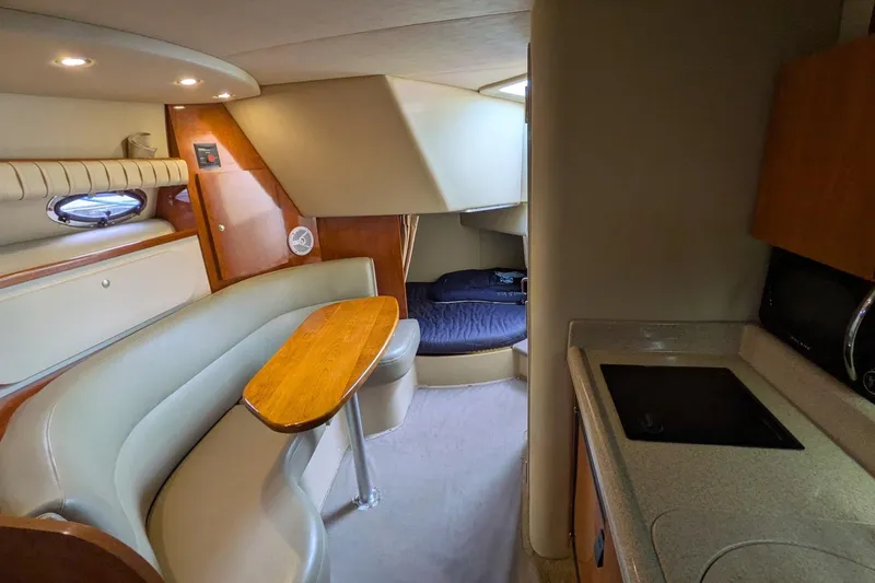 Slide: The Image of Interior of 2005 Cruisers Yachts 280 CXi Express, featuring dining area and compact kitchen. - 4