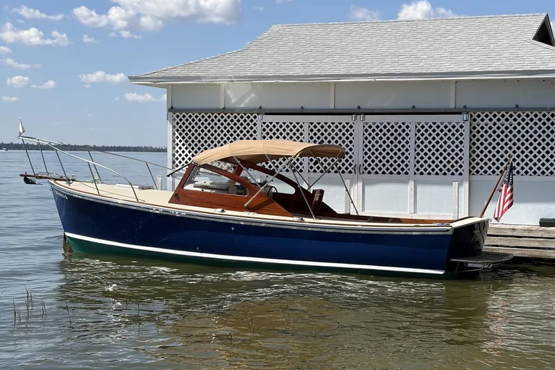The Image of 1973 Dyer 29 Bass Boat docked by a boathouse on a sunny day. - 1