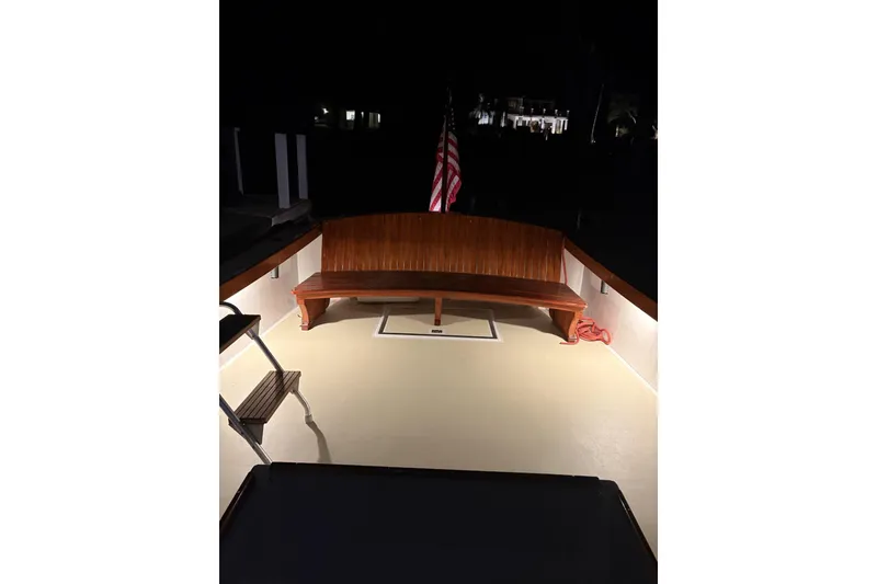 Slide: The Image of 1973 Dyer 29 Bass Boat deck at night with wooden bench and American flag. - 12