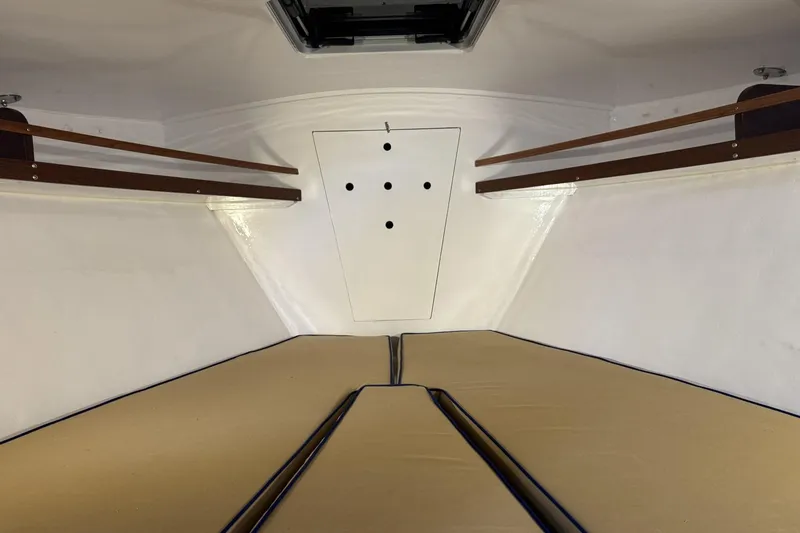 Slide: The Image of Interior cabin of a 1973 Dyer 29 Bass Boat with beige cushions and wooden shelves. - 13