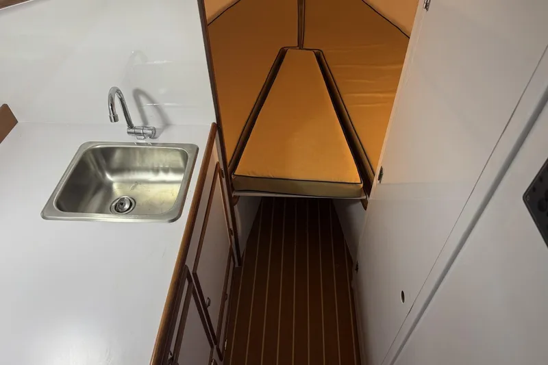 Slide: The Image of 1973 Dyer 29 Bass Boat interior with sink and cozy sleeping area. - 14