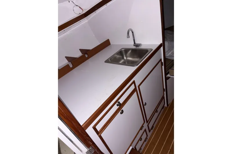 Slide: The Image of 1973 Dyer 29 Bass Boat interior with sink and wooden cabinetry. - 15
