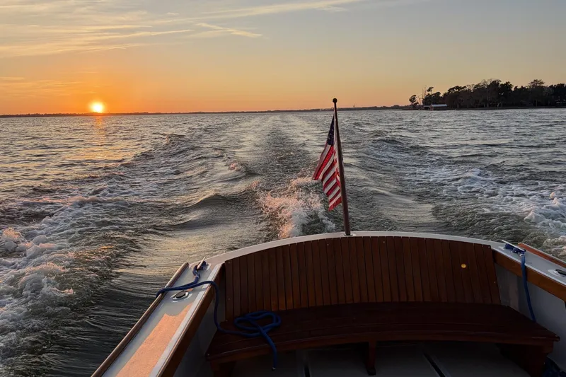 Slide: The Image of 1973 Dyer 29 Bass Boat cruising at sunset with American flag, serene water view. - 16