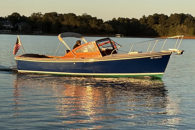 Slide: The Image of Vintage 1973 Dyer 29 Bass Boat cruising on a serene lake at sunset. - 2