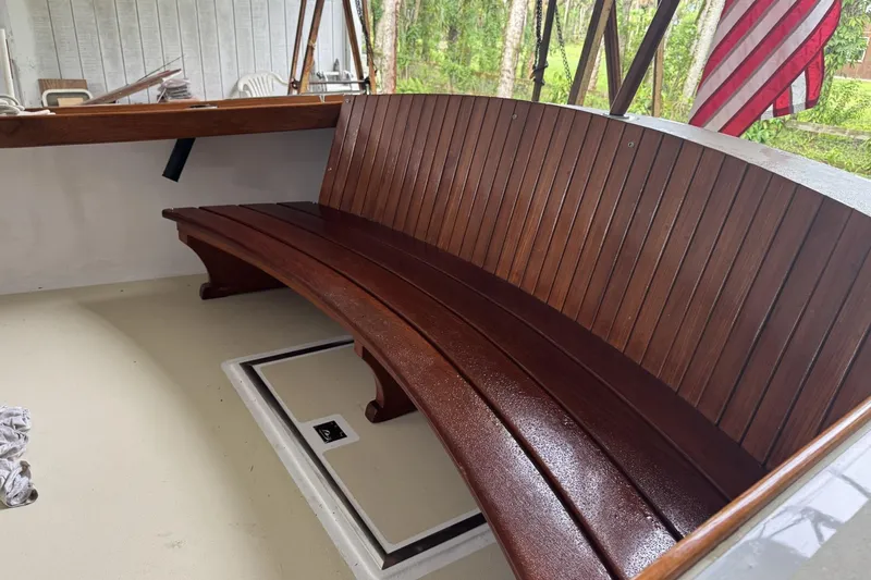 Slide: The Image of 1973 Dyer 29 Bass Boat with polished wooden bench and American flag in background. - 6
