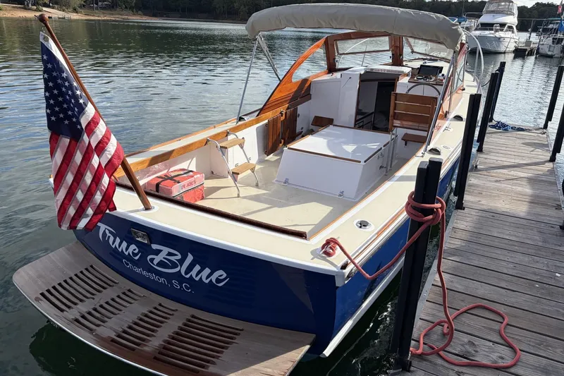 Slide: The Image of 1973 Dyer 29 Bass Boat docked, featuring "True Blue" name and American flag. - 8