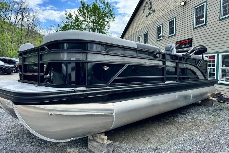 The Image of 2026 Bennington 23 pontoon boat displayed outside a marina, showcasing sleek design. - 0