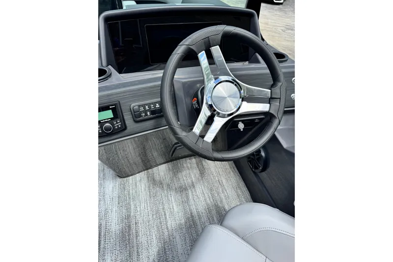 Slide: The Image of Steering wheel and dashboard of 2026 Bennington S 23 SSR boat, featuring modern controls. - 12