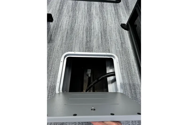 Slide: The Image of Open storage compartment on 2026 Bennington S 23 SSR boat with gray flooring. - 16