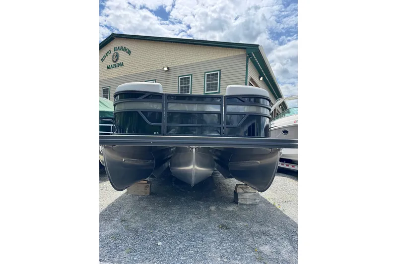 Slide: The Image of 2026 Bennington 23 pontoon boat at Snug Harbor Marina under a cloudy sky. - 2
