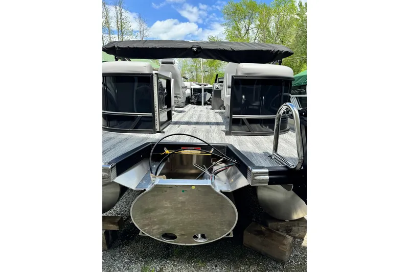 Slide: The Image of 2026 Bennington 23 pontoon boat with sleek design and modern features, docked outdoors. - 3