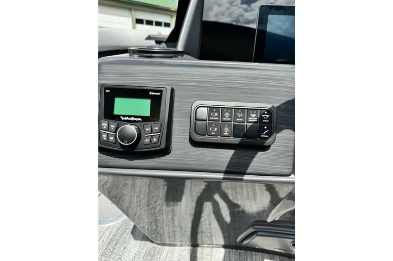 Slide: The Image of Control panel of 2026 Bennington S 23 SSR boat with audio system and switches. - 9