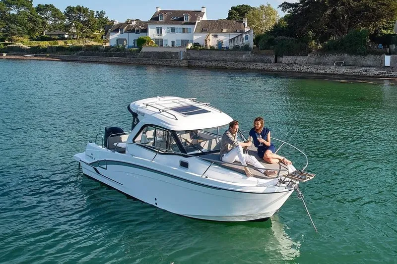 Slide: The Image of 2026 Beneteau Antares 7 boat on calm water near coastal house. - 1