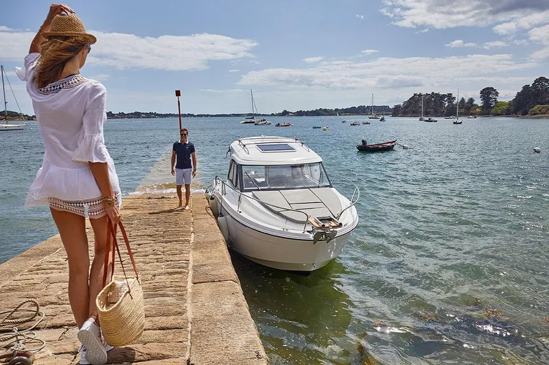 Slide: The Image of Beneteau Antares 7 2026 docked with people in summer attire. - 21