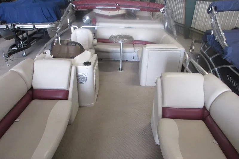 Slide: The Image of 2014 Manitou 22 Aurora pontoon boat interior with beige and maroon seating. - 2
