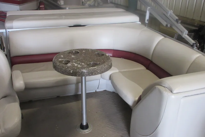 Slide: The Image of 2014 Manitou 22 Aurora boat interior with beige seating and a round table. - 4
