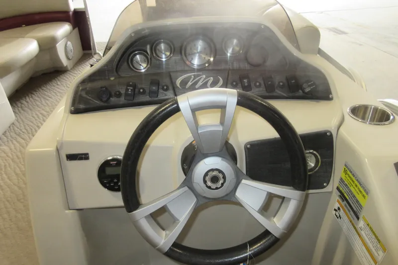 Slide: The Image of Dashboard of a 2014 Manitou 22 Aurora boat with steering wheel and controls. - 6