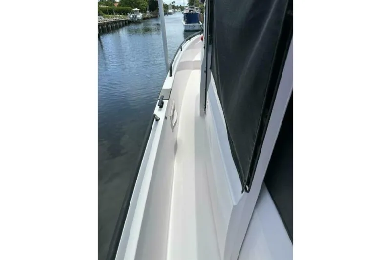 Slide: The Image of 2021 Axopar Brabus 37 XC Cross Cabin side view on calm waterway. - 19