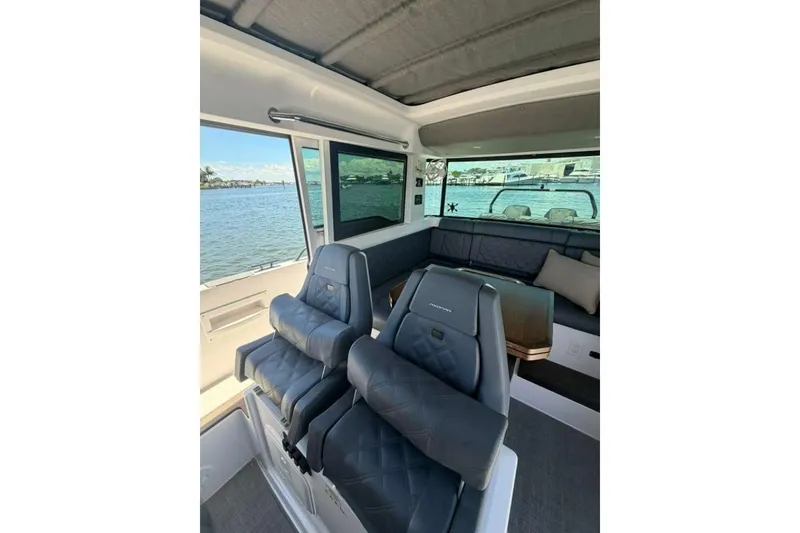 Slide: The Image of Interior of 2021 Axopar Brabus 37 XC Cross Cabin with luxurious seating and waterfront view. - 31