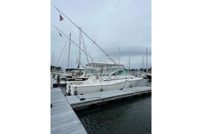 The Image of 1999 Cabo 35 Express boat docked at marina with overcast sky. - 0