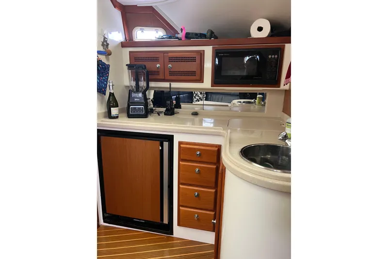 Slide: The Image of Compact kitchen area in a 1999 Cabo 35 Express boat with microwave and blender. - 11