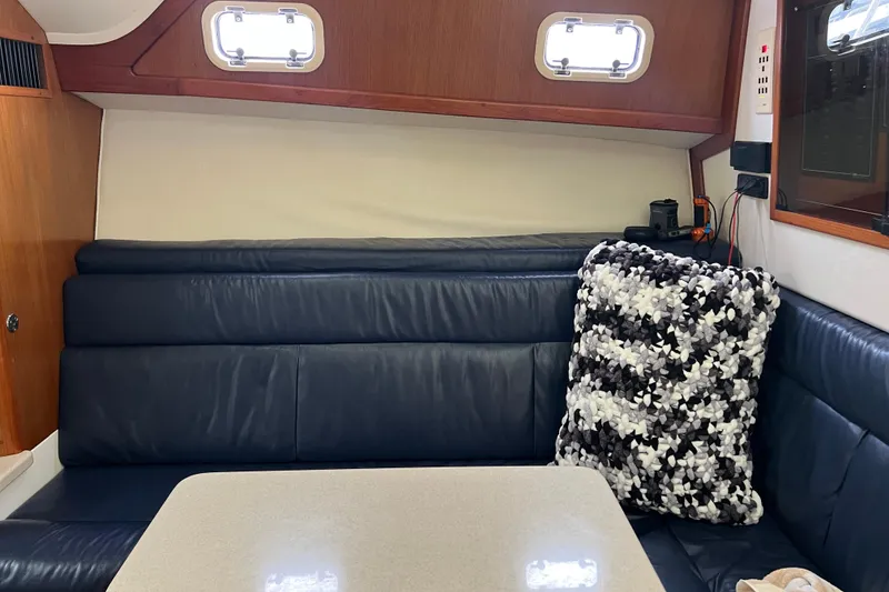 Slide: The Image of Interior of a 1999 Cabo 35 Express boat with leather seating and a patterned cushion. - 12