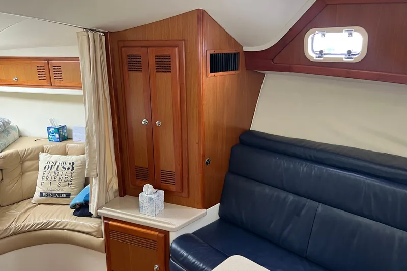 Slide: The Image of Interior of a 1999 Cabo 35 Express boat with wood cabinetry and leather seating. - 13