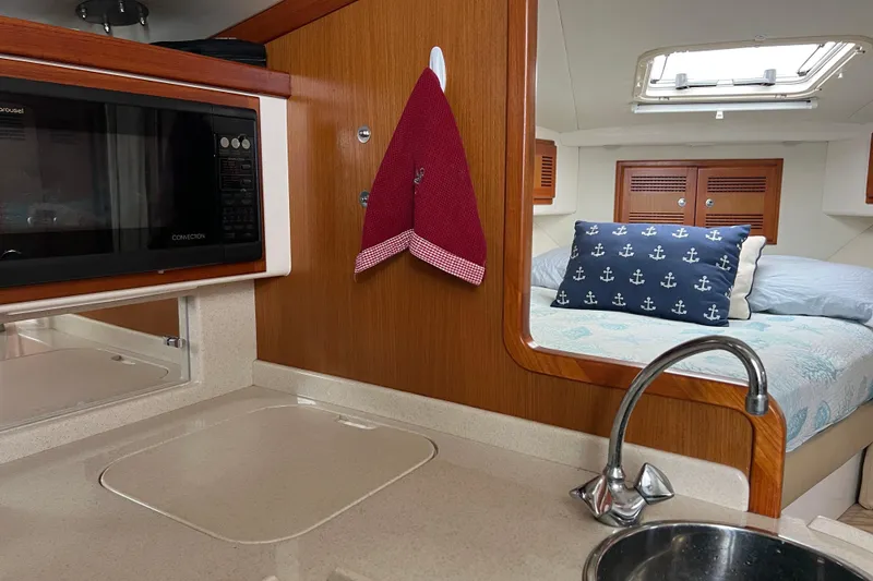 Slide: The Image of Interior of 1999 Cabo 35 Express yacht with kitchenette and cozy sleeping area. - 15