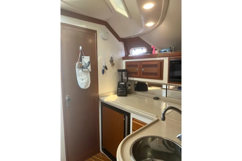 Slide: The Image of Interior of 1999 Cabo 35 Express yacht kitchen with wooden cabinets and modern appliances. - 18
