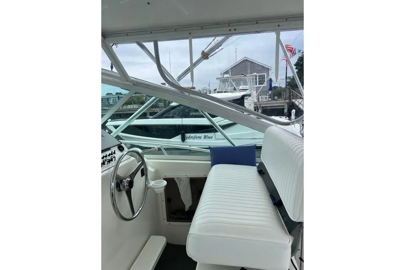 Slide: The Image of Interior view of a 1999 Cabo 35 Express boat with white seating and steering wheel. - 3