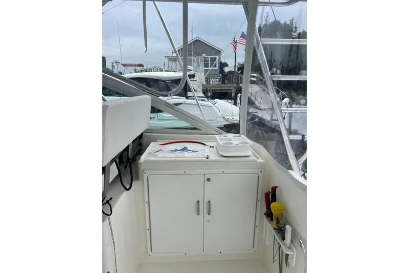 Slide: The Image of 1999 Cabo 35 Express boat interior with storage cabinet and fishing gear. - 5