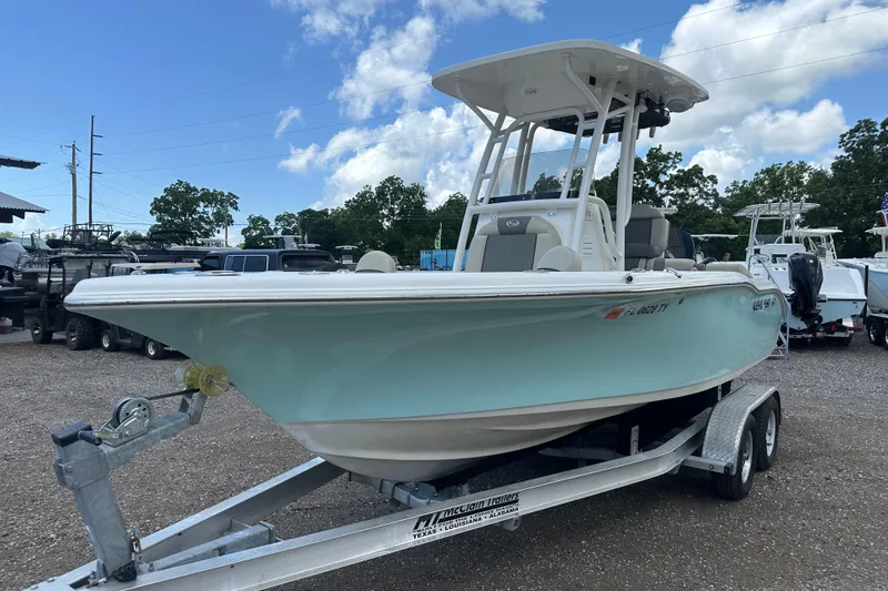 The Image of 2025 Key West 219 FS boat on trailer, parked outdoors under a blue sky. - 0