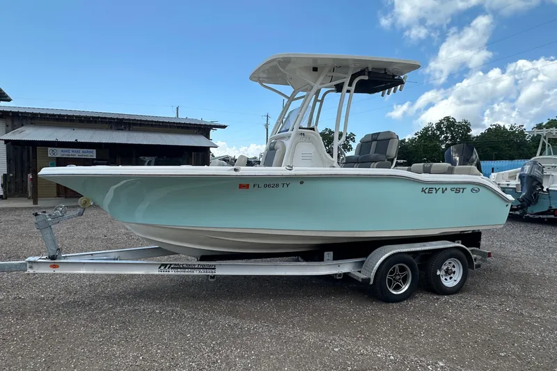 Slide: The Image of 2025 Key West 219 FS boat on trailer, parked outdoors under a clear sky. - 1