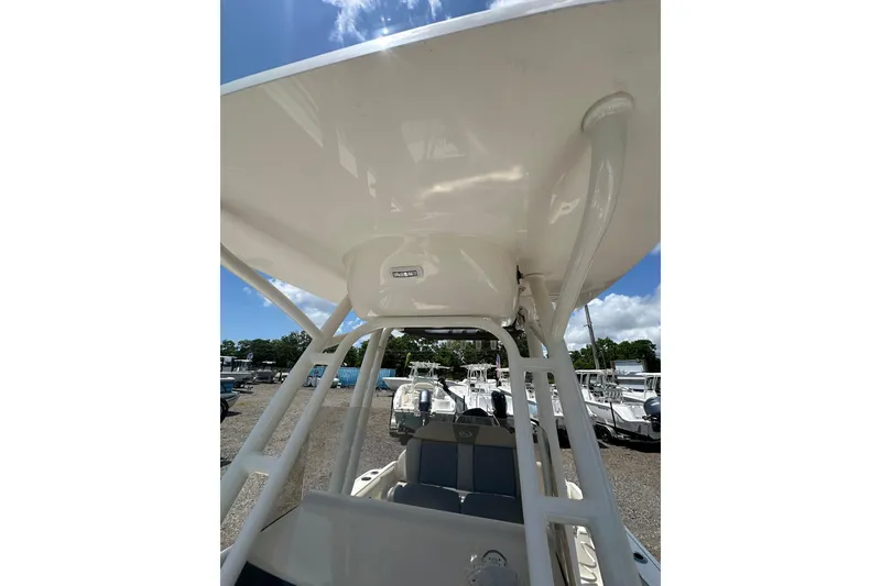 Slide: The Image of 2025 Key West 219 FS boat interior with T-top under sunny sky. - 19
